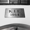 Interior. Detail of Brass plaque over entrance. Inscribed K.I.E. 1864.