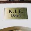 Interior. Detail of Brass plaque over entrance. Inscribed K.I.E. 1864.