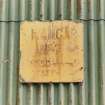 Evanton Airfield technical area, plate on rear of Admiralty 'S' type aircraft shed, detail of manufacturer's plate with notice saying 'Hangar No.7 S.N.S.O. Rosyth Key H'.