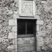 View of doorway (now window) with armorial panel above on south face of barn