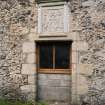 View of doorway (now window) with armorial panel above on south face of barn