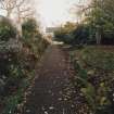 View of gravel path in front of plant border leading to garden front of Geanies house