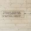 Tain Airfield Operations Block, upper main corridor, detail of sign painted on wall 'Through corridor to Intelligence, Met. & Tactical Library'.