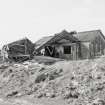 View from NE showing collapsed and standing asbestos roofed huts.