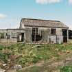 View fom E showing standing remains of asbestos roofed hut with timber extension.