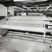 New Loom Flat:  View of Re-beaming Machine being operated by Colin Dent, who is using a portable knotting machine