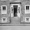 Detail of SE elevation showing main entrance, centre bay windows and iron railings.