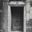 Leith, 10 Burgess Street.
View of doorway with fleur de lis decorated lintel, surmounted by open-topped pediment with thisle decoration.