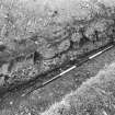 Excavation photograph showing a section of berm outside the W wall, with fallen blocks.