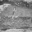 Excavation photograph: Pre-Roman building. Bedding-trench for timbers (section at NW corner) looking E