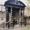 View of funerary monument on West wall of churchyard