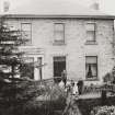 Historic photographic view of S elevation with figures standing at entrance.
Insc: 'no. 2, Hillside House, Duddingston, April 1909, J B W'.
