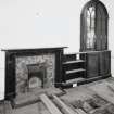 Interior, ground floor, North East room, view of fireplace and bookcase.