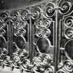 Interior-detail of wrought iron balustrade in front of curved bench in chapel.