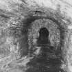 Detail of firebox with semi-circular iron lintel/surround and masonry sill