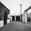 View of entrance and outbuilding from N.