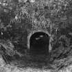 Detail inside shaft of kiln at W end of range, showing inside of draw hole and part of kiln 
floor and lining.