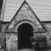 Detail of arched entrance in gabled portico with cross finial