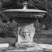 East fountain, relief mask on square stem underneath circular basin, detail