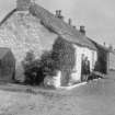 Iona, Baile Mor, Cottages.
View of thatched cottage with figure.