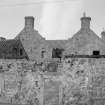 View from SE showing derelict front elevation of 16 Station Road, Kincardine on Forth, with 9-13 Ashbraes behind.