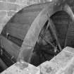 Interior view: detail of recently-restored iron-framed undershot water wheel (with wooden buckets)