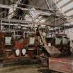 Interior view of boiler house showing two main boilers with semi-automated coal feed.  Also visible is a electrical wall panel and the steel roof trusses.