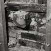 Interior.
Detail of first floor S wall showing sawn off beam end.