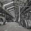 Interior.
View of ropery from W of take-off end of dual-purpose closing and stranding machine (B7 & 8), used to produce wire ropes, including lock-coil bridge ropes.