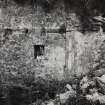 Interior.
View of window and blocked doorway in re-entrant angle of N wall.