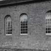 Detail of arched windows and stonework including blocked doorway