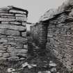 View of passage between dwelling and farm building from N.