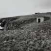 General view of site from SSW (searchlight emplacement) showing engine house with gun-emplacements in the background.