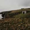 General view of site from SSW (searchlight emplacement) showing engine house with gun-emplacements in the background.