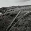 View of SW searchlight emplacement,detail of concrete access steps from SW.  Engine room and gun-emplacements in the background.