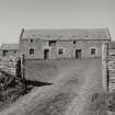 View of threshing barn through gate to S