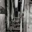 View of drive pulleys and belts for machine, side wall of building on left and the threshing machine on the right