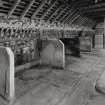 View of interior of byre from W end, byre located in E end of N range