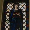 View of reused stained glass window depicting a lady to the East of the organ..
