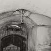 View of underpass at W end of station with glazed brick vaulting, and ornate iron light fittings and gate.