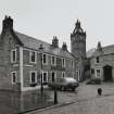 View of Montgomerie Arms Hotel with Old Parish Church behind, from NE