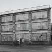 Elevation view from N of main facade of factory