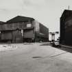 View from SW of detached Fabrication Shop block (formerly Boiler Shop), situated on N side of East Hamilton Street, with the giant cantilever crane of James Watt Dock (NS27NE 17) visible in distance, photographed 10 August 1993