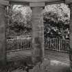 Gazebo, upper level, view from interior past pillars supporting entrance towards garden