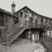 View from E of ornate iron stair and balcony leading to upper floor of building fronting High Street.  Photosurvey 22-APR-1992