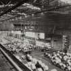 Interior.
View of overhead gantry crane loading steel coils onto lorry in despatch area.