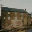 View of mill from SE, showing lade and water wheel on left, mill in centre and one of the two kilns on right.