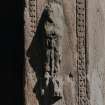 Detail of carved figure to right of doorway on W side of tower.