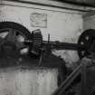 Interior. ground floor of mill, view from E of gear cupboard showing arrangement of gears and shafts transferring power from the water wheel (on the other side of the wall) to belt pulleys