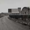 View from ESE of S blocks of duty-free warehouses with Glenesk Maltings and silos in background.